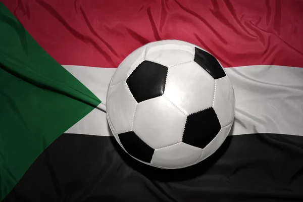 Черно-белый футбольный мяч на государственном флаге Судана — стоковое фото