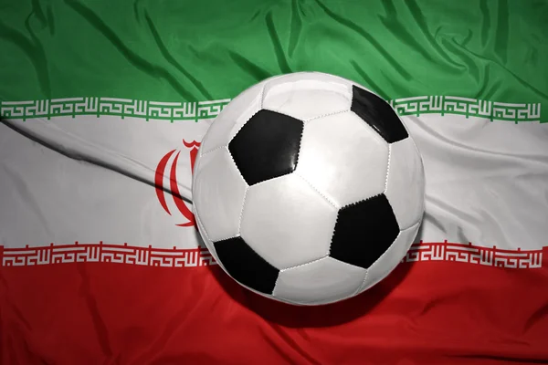 Pallone da calcio bianco e nero sulla bandiera nazionale di iran — Foto Stock
