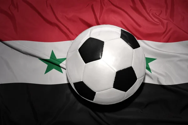 Pelota de fútbol blanco y negro en la bandera nacional de Siria — Foto de Stock