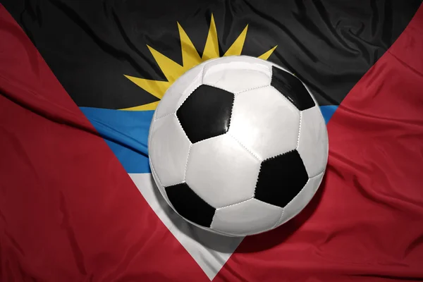 Черно-белый футбольный мяч на государственном флаге Антигуа и Барбуды — стоковое фото