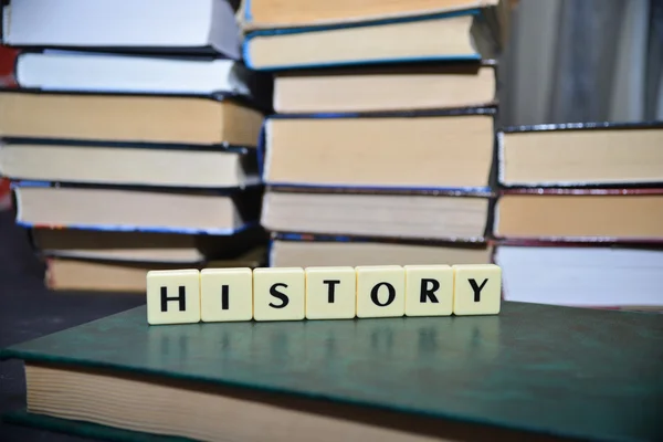 Ordet historia nära högen av böcker — Stockfoto