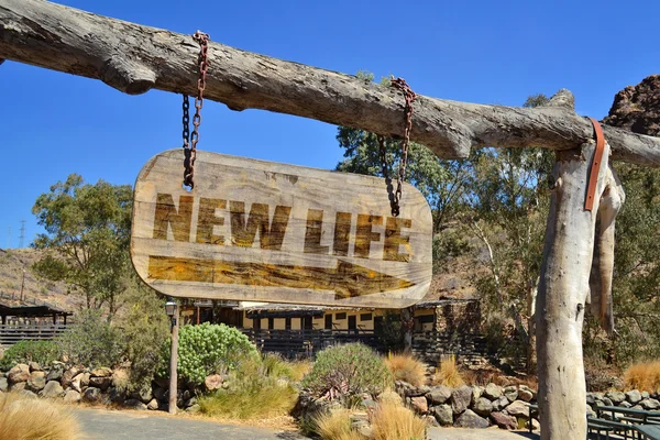 Old wood signboard with arrow and text "new life " hanging on a branch — Stock Photo, Image
