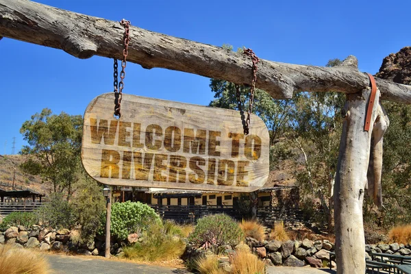 Stare drewno szyld z tekstem "Welcome to Riverside" wiszące na gałęzi — Zdjęcie stockowe
