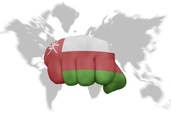 Fist with the national flag of oman on a world map background — Stock Photo, Image