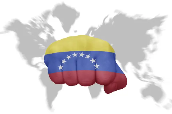Puño con la bandera nacional de venezuela en un mapa mundial de fondo — Foto de Stock
