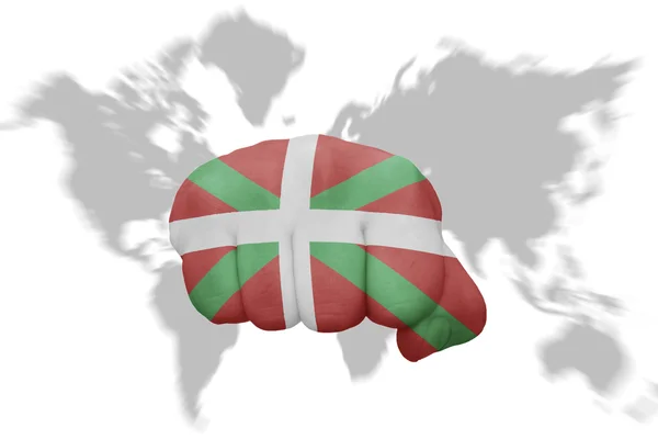 Dünya harita arka plan üzerinde Bask Ülkesi bayrağı ile yumruk — Stok fotoğraf