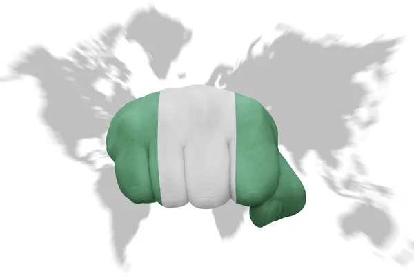 Puño con la bandera nacional de nigeria en un mapa del mundo fondo — Foto de Stock