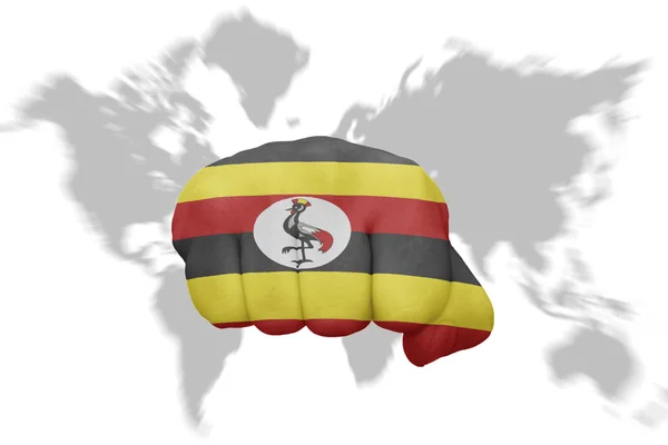 Pięść z flagi narodowej Ugandy na tle mapy świata — Zdjęcie stockowe