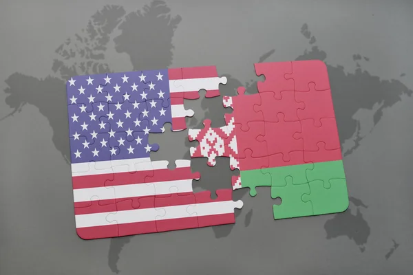 Puzzle con la bandiera nazionale degli Stati Uniti d'America e Bielorussia su uno sfondo mappa del mondo — Foto Stock