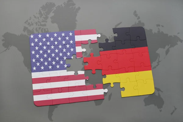 Quebra-cabeça com a bandeira nacional dos estados unidos da américa e alemanha em um mapa mundial de fundo — Fotografia de Stock