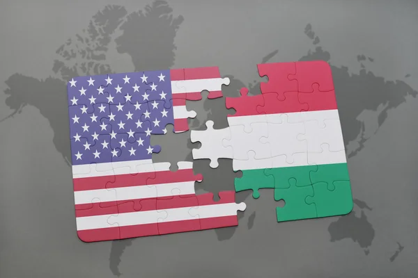 Bir dünya haritası arka plan üzerinde Amerika ve Macaristan Birleşik Devletleri ulusal bayrağı ile bulmaca — Stok fotoğraf