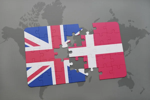 Puzzle avec le drapeau national de la Grande Bretagne et du Danemark sur un fond de carte du monde — Photo