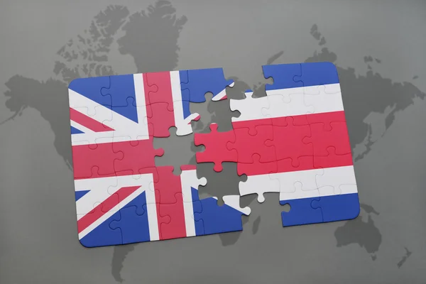 Puzzle avec le drapeau national de la Grande Bretagne et de Costa Rica sur un fond de carte du monde . — Photo