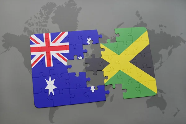 Rompecabezas con la bandera nacional de Australia y jamaica en un mapa del mundo de fondo . — Foto de Stock
