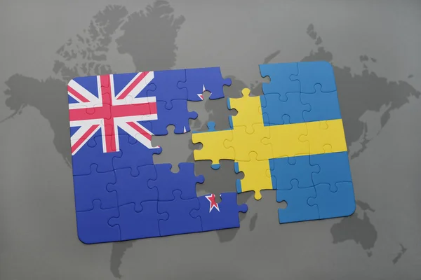 Rompecabezas con la bandera nacional de Nueva Zelanda y Suecia en un mapa del mundo fondo — Foto de Stock