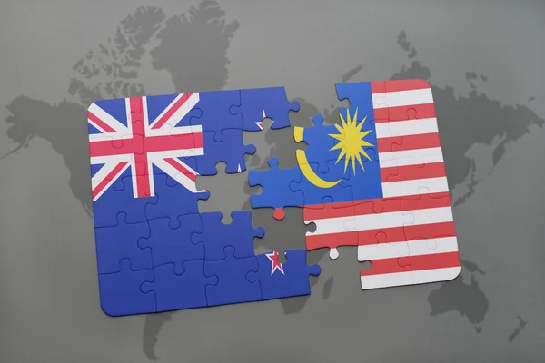 Puzzle with the national flag of new zealand and malaysia on a world map background. 3D illustration — Stock Photo, Image