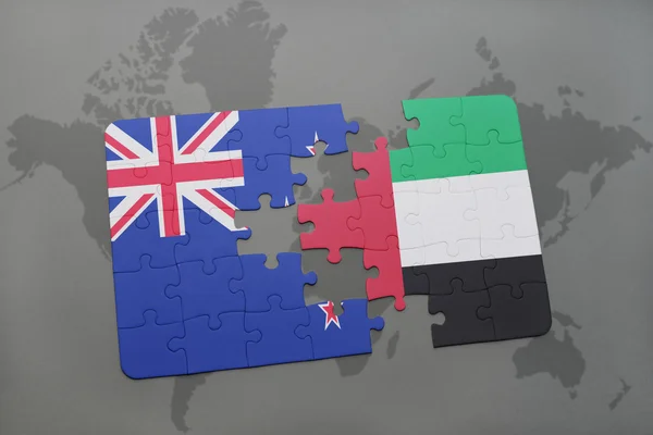 Quebra-cabeça com a bandeira nacional da Nova Zelândia e emirados árabes unidos em um fundo de mapa do mundo. Ilustração 3D — Fotografia de Stock