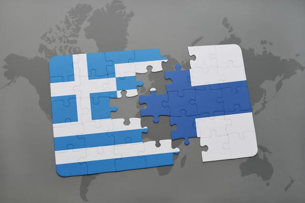 Puzzle mit der Nationalflagge Griechenlands und Finnlands auf einem Weltkartenhintergrund. — Stockfoto