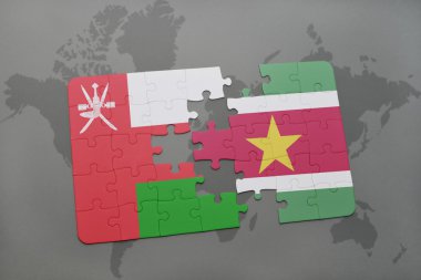 bir dünya haritası arka plan üzerinde umman ve surinam ulusal bayrağı ile bulmaca.