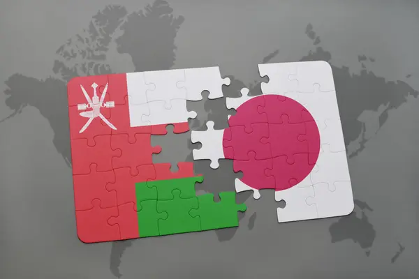 Головоломка з національним прапором Оман і Японія на карті світу фону. — стокове фото