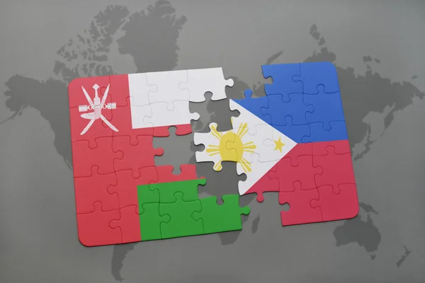 世界地図の背景にオマーンとフィリピンの国旗とパズル. — ストック写真