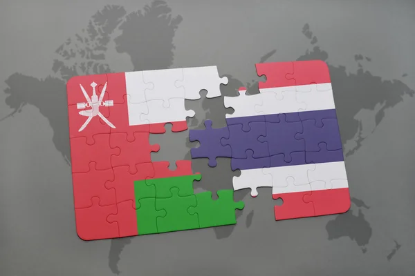 Puzzle mit der Nationalflagge von Oman und Thailand auf einer Weltkarte Hintergrund. — Stockfoto