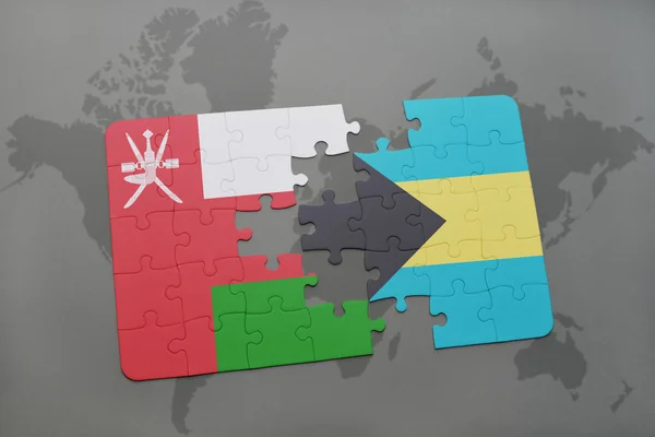 Puzzel met de nationale vlag van Oman en bahama's op een wereld kaart achtergrond. — Stockfoto