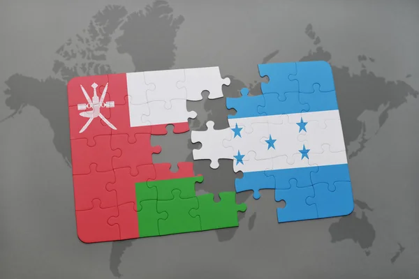 Puzzle con la bandiera nazionale di oman e honduras su sfondo mappa del mondo . — Foto Stock