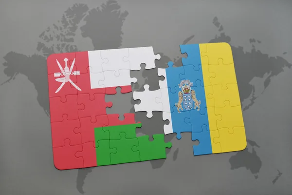 Puzzle con la bandiera nazionale delle isole oman e canary su uno sfondo mappa del mondo . — Foto Stock