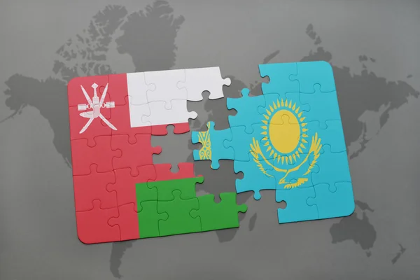 Quebra-cabeça com a bandeira nacional de oman e kazakhstan em um fundo do mapa do mundo . — Fotografia de Stock