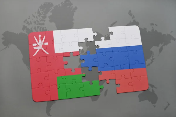 Puzzel met de nationale vlag van oman en Rusland op de achtergrond van een wereld kaart. — Stockfoto