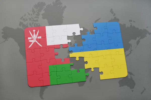 Puzzel met de nationale vlag van oman en Oekraïne op de achtergrond van een wereld kaart. — Stockfoto