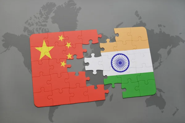 Puzzle con la bandiera nazionale di Cina e India su uno sfondo mappa del mondo . — Foto Stock