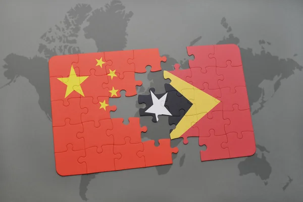世界地図の背景に中国と東ティモールの国旗とパズル. — ストック写真