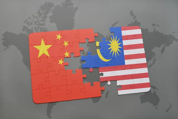 Hádanka s národní vlajkou Číny a Malajsie na pozadí mapy světa. — Stock fotografie
