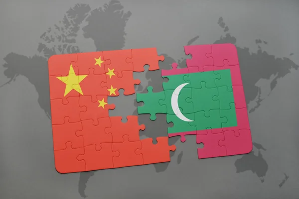 世界地図の背景に中国とモルディブの国旗とパズル. — ストック写真