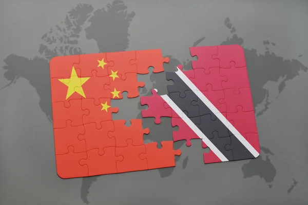 Puzzle avec le drapeau national de la Chine et de Trinidad et tobago sur un fond de carte du monde . — Photo