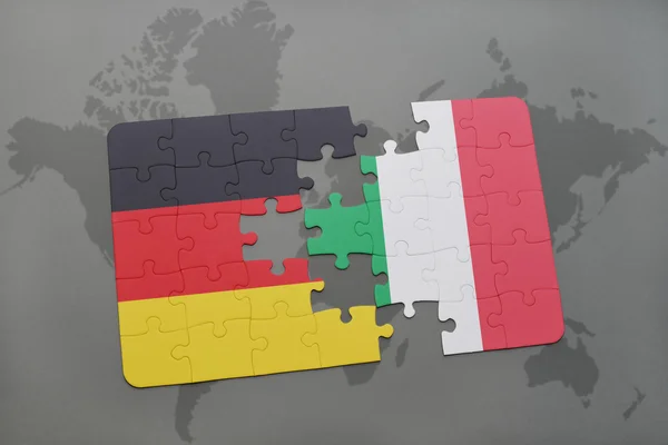 Quebra-cabeça com a bandeira nacional da alemanha e itália em um fundo de mapa do mundo . — Fotografia de Stock
