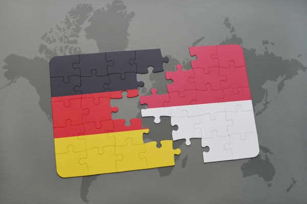 Puzzel met de nationale vlag van Duitsland en Indonesië op een wereld kaart achtergrond. — Stockfoto