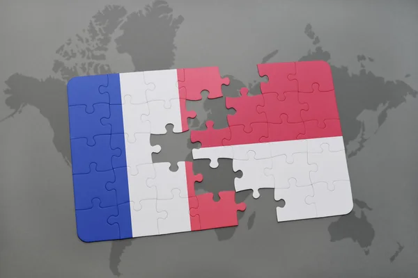 Puzzle mit der Nationalflagge von Frankreich und Indonesien auf einer Weltkarte Hintergrund. — Stockfoto