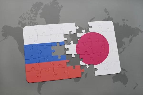 世界地图背景上俄罗斯和日本国旗的谜题. — 图库照片
