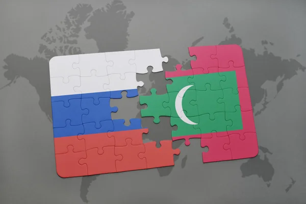 Puzzle avec le drapeau national de la Russie et des Maldives sur un fond de carte du monde . — Photo