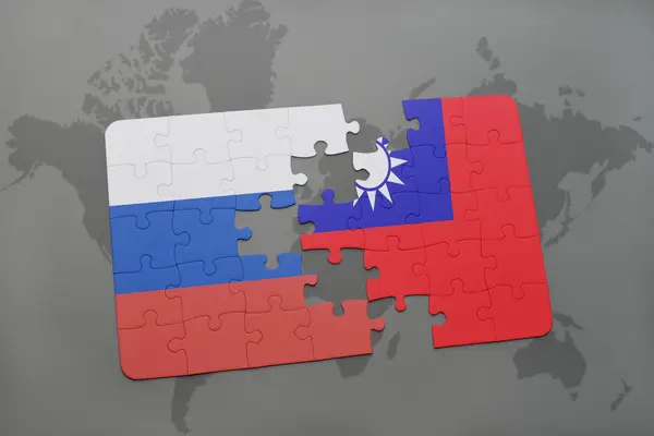 Puzzel met de nationale vlag van Rusland en Taiwan op een wereld kaart achtergrond. — Stockfoto