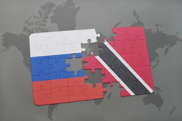 Puzzle con la bandiera nazionale di russia e trinidad e tobago su uno sfondo mappa del mondo . — Foto Stock