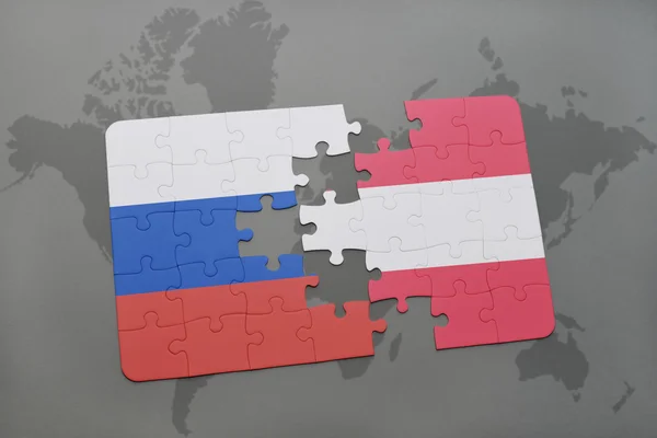 Bir dünya haritası arka plan üzerinde Rusya ve Avusturya ulusal bayrağı ile bulmaca. — Stok fotoğraf