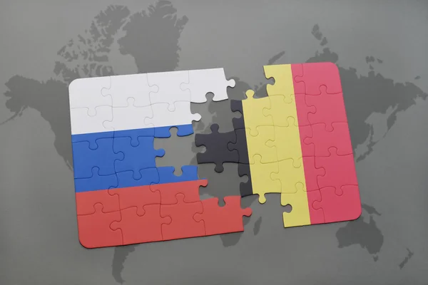 Puzzle con la bandiera nazionale di russia e belgio su sfondo mappa del mondo . — Foto Stock