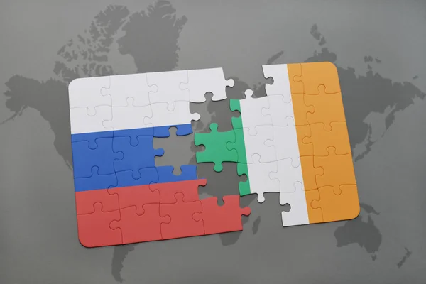 Bir dünya haritası arka plan üzerinde Rusya ve İrlanda ulusal bayrağı ile bulmaca. — Stok fotoğraf