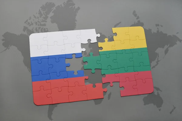 Puzzle avec le drapeau national de la Russie et la lithuanie sur un fond de carte du monde . — Photo