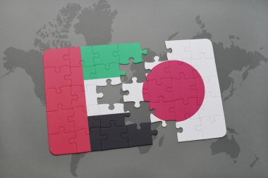 puzzle with the national flag of united arab emirates and japan on a world map background.