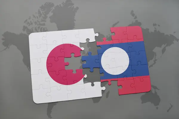 Puzzle avec le drapeau national du Japon et laos sur un fond de carte du monde . — Photo